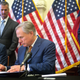 State Rep. Chris Paddie (L) and State Senator Kelly Hancock (R) watch as Texas Governor Greg Abbott signs Senate Bills 2 and 3 during a press conference at the Capitol on June 8, 2021 in Austin, Texas. Governor Abbott signed the bills into law to reform the Electric Reliability Council of Texas and weatherize and improve the reliability of the state's power grid.